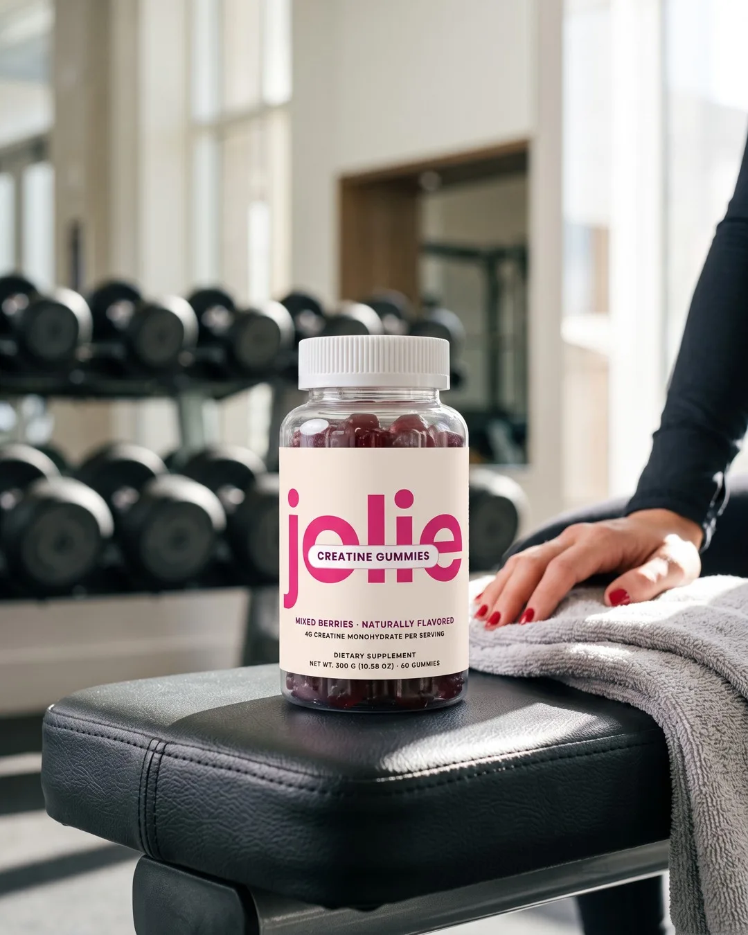 A jar of jolie Creatine gummies on a gym bench